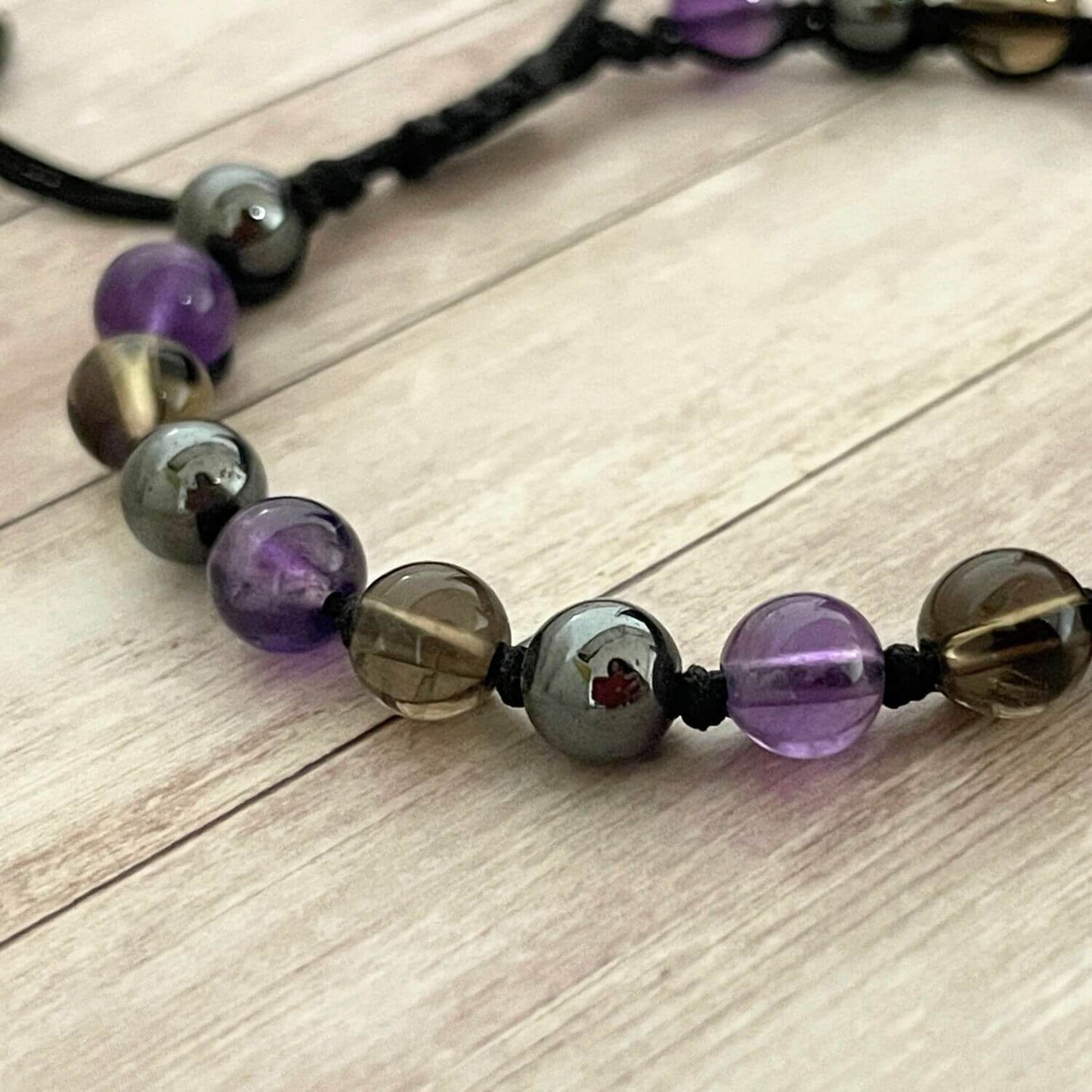 Gros plan des pierres naturelles Améthyste, Hématite et Quartz Fumé, bracelet ancrage et nouvelles habitudes.