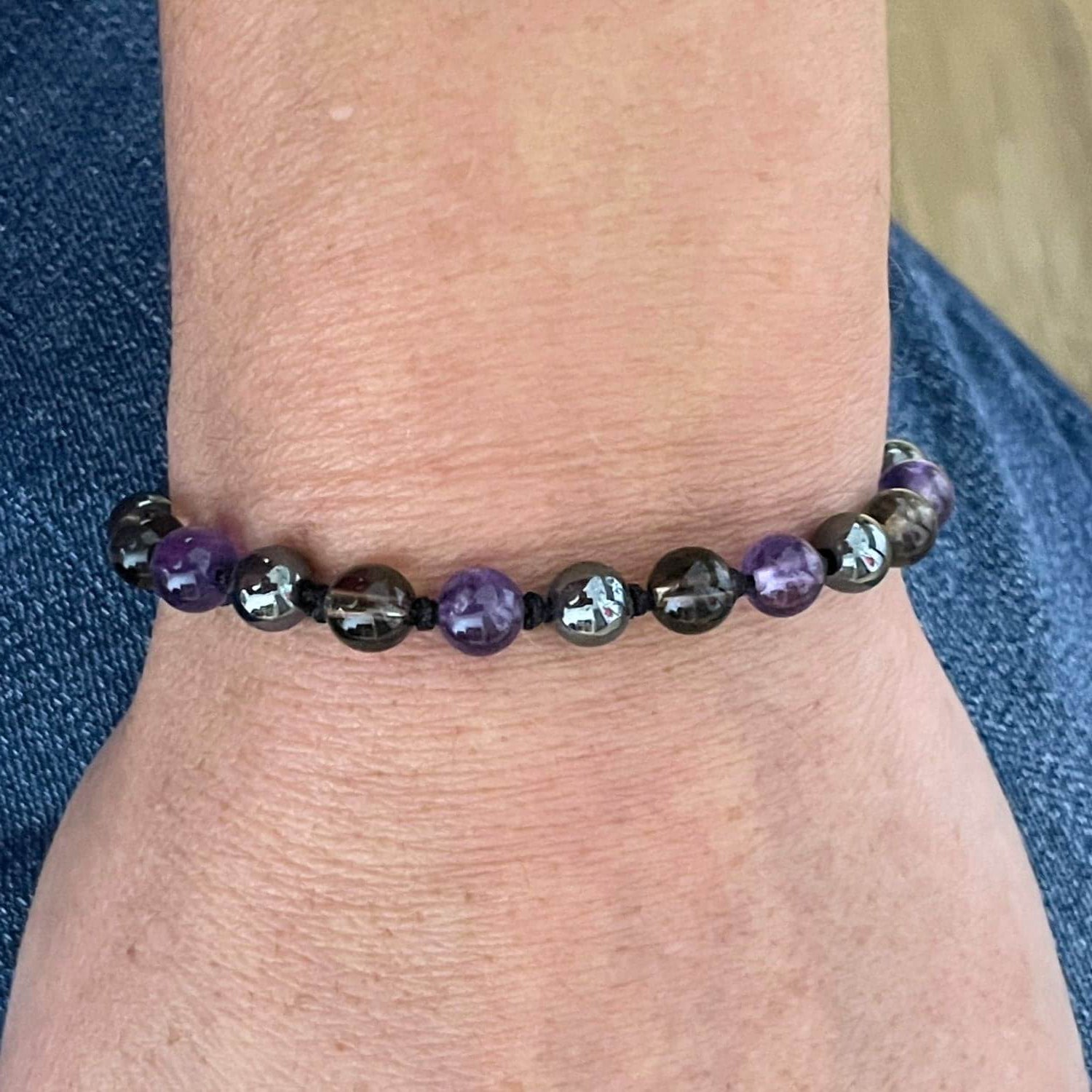 Bracelet Améthyste Hématite Quartz Fumé porté au poignet, bijou en pierres naturelles.