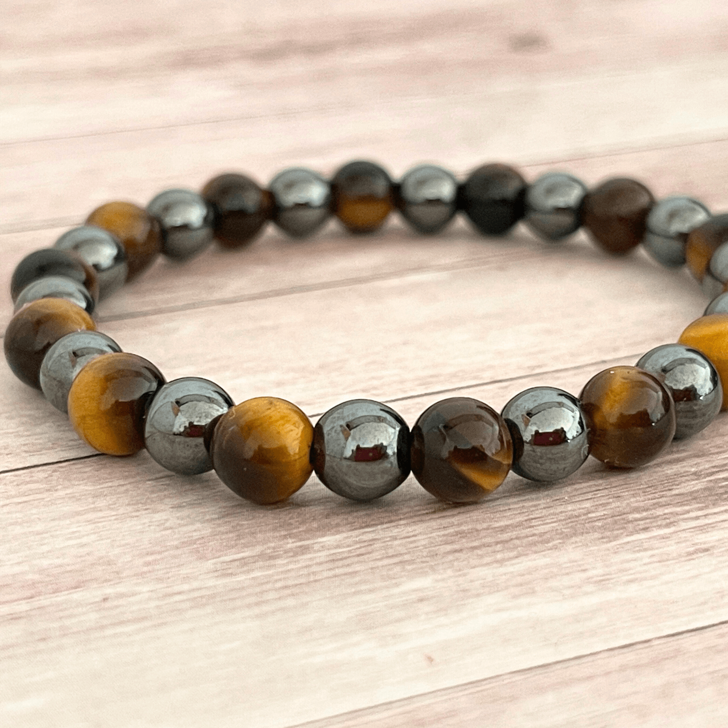 Gros plan sur les perles d’oeil de tigre et d’hématite du bracelet en pierres naturelles