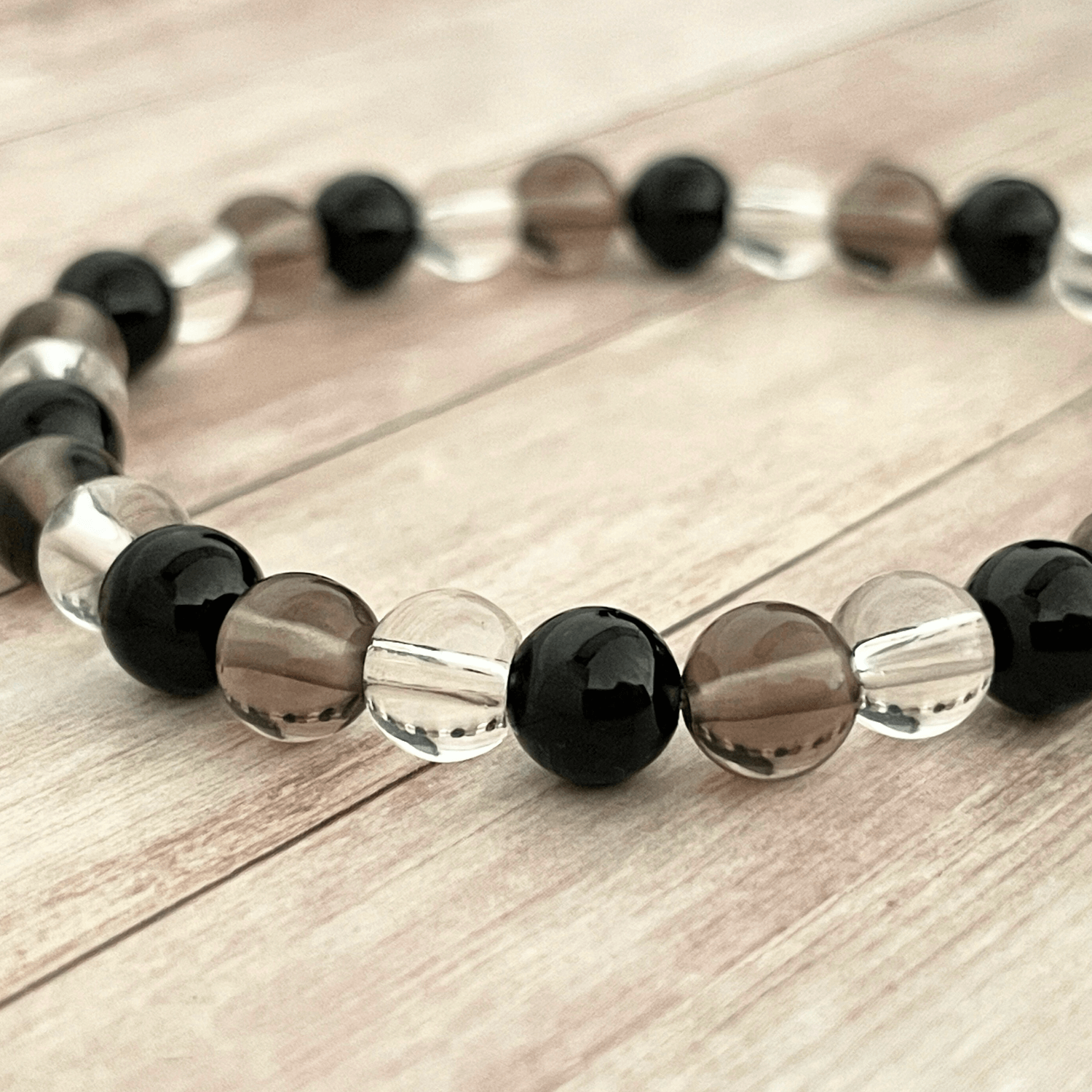 Gros plan sur les perles de tourmaline, quartz fumé et cristal de roche du bracelet