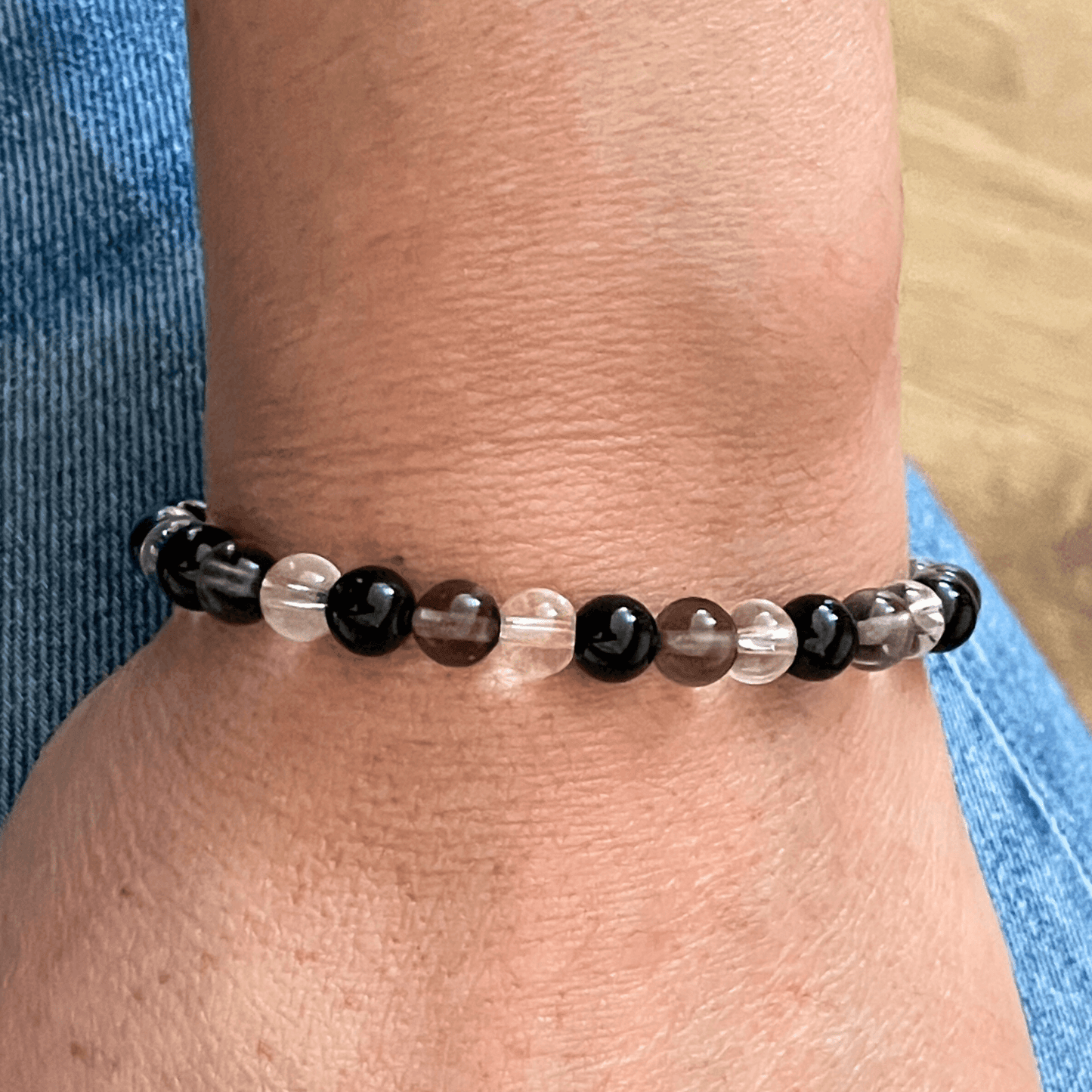 Bracelet tourmaline, quartz fumé et cristal de roche porté au poignet, bijou en pierres naturelles