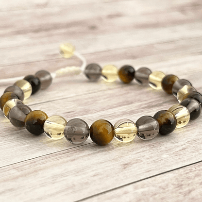 Gros plan sur les perles d’oeil de tigre, citrine et quartz fumé du bracelet