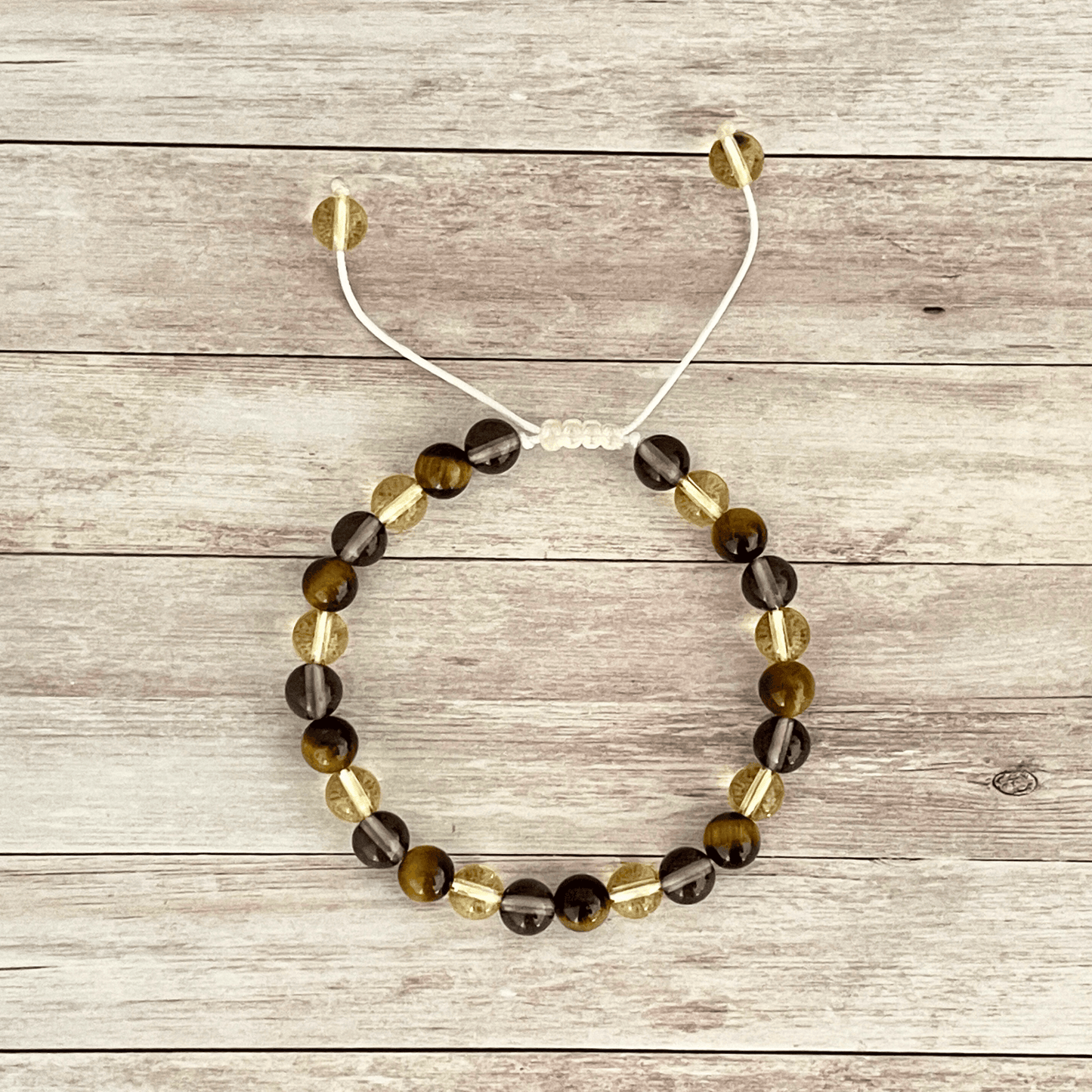 Vue de dessus du bracelet oeil de tigre, citrine et quartz fumé, perles alignées sur cordon