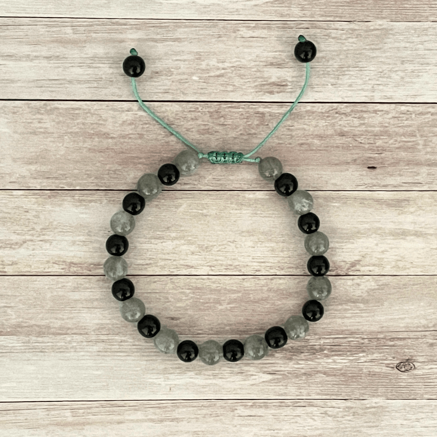 Vue de dessus du bracelet labradorite et onyx, perles en pierres naturelles alignées sur cordon