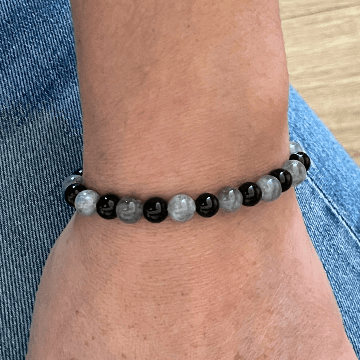 Bracelet labradorite et onyx porté au poignet, bijou en pierres naturelles sur cordon ajustable