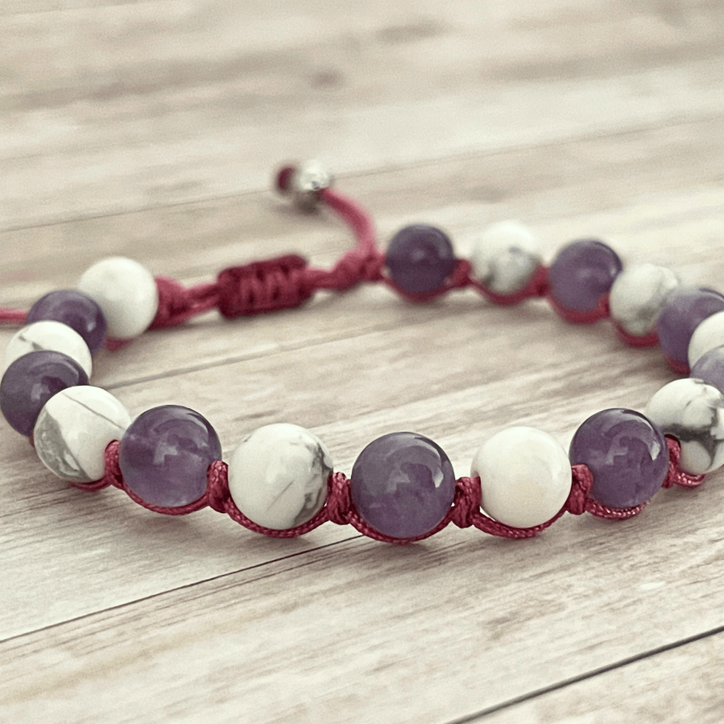 Gros plan sur les perles d’améthyste violette et de howlite blanche du bracelet en pierres naturelles
