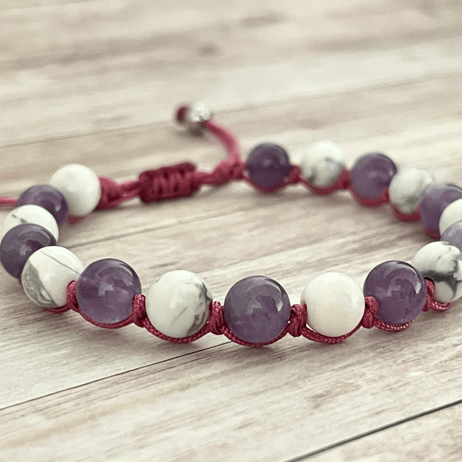 Gros plan sur les perles d’améthyste violette et de howlite blanche du bracelet en pierres naturelles
