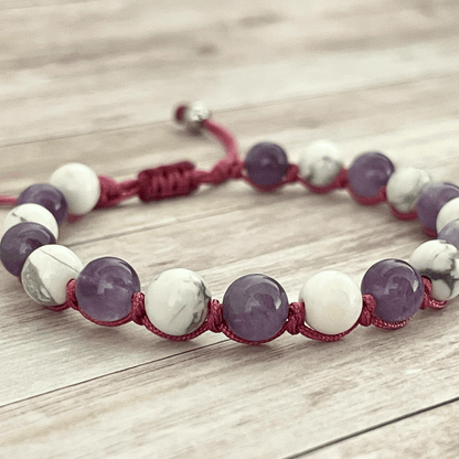 Gros plan sur les perles d’améthyste violette et de howlite blanche du bracelet en pierres naturelles