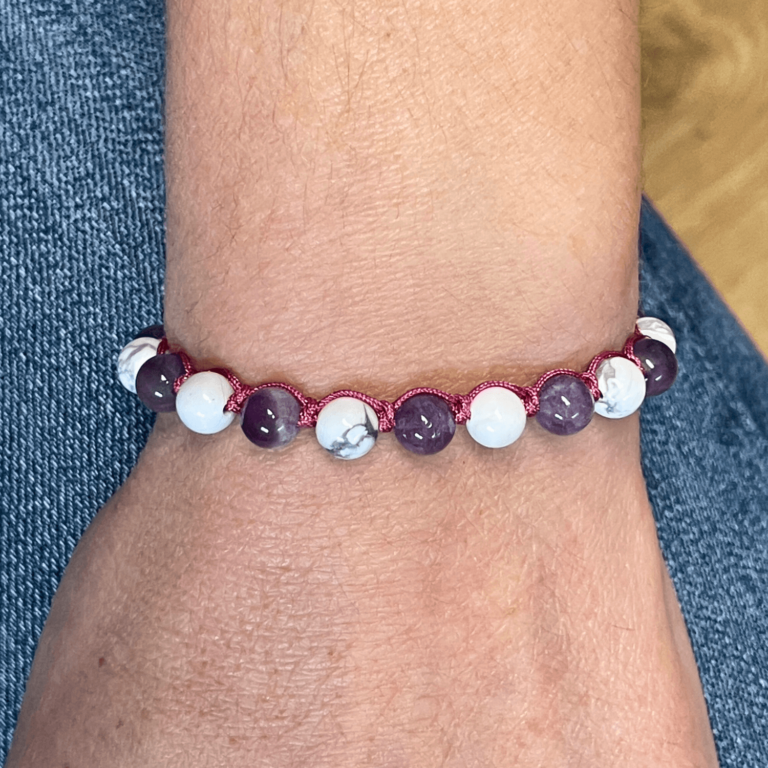 Bracelet améthyste et howlite porté au poignet, cordon ajustable et perles en pierres naturelles