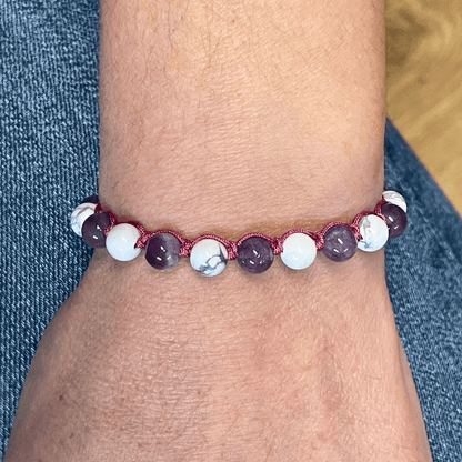 Bracelet améthyste et howlite porté au poignet, cordon ajustable et perles en pierres naturelles