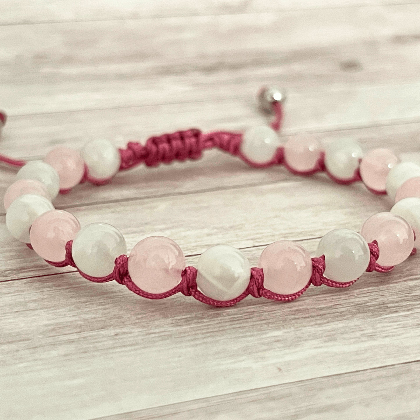 Gros plan sur les perles de quartz rose et de pierre de lune du bracelet en pierres naturelles