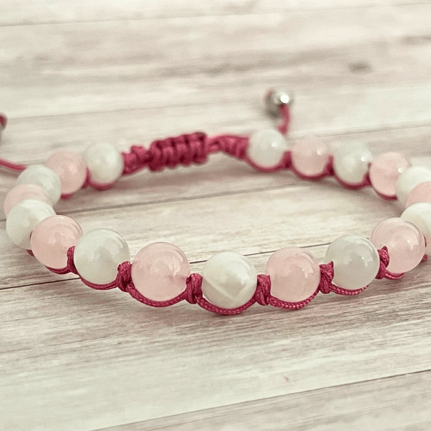 Gros plan sur les perles de quartz rose et de pierre de lune du bracelet en pierres naturelles