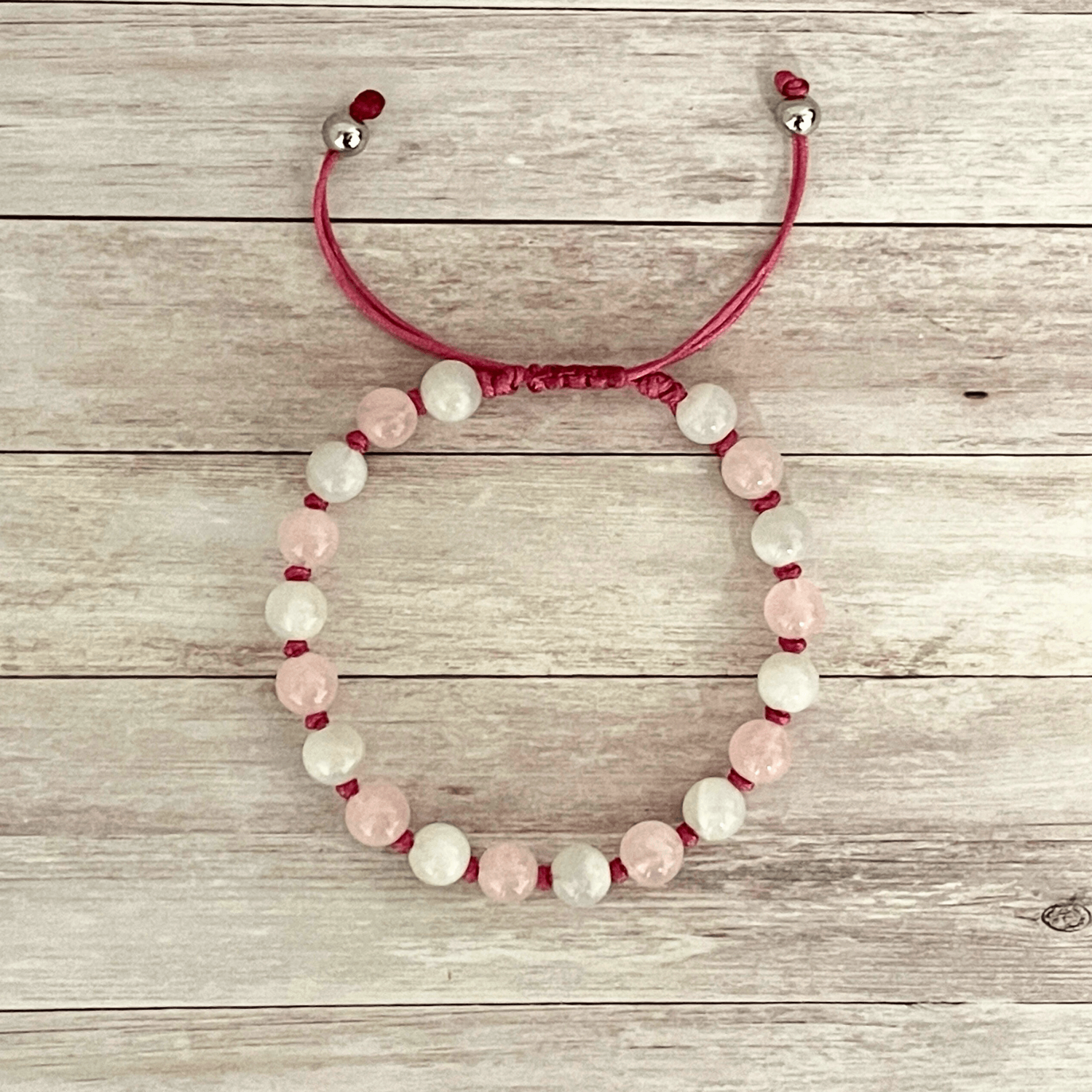 Vue de dessus du bracelet quartz rose et pierre de lune, perles alignées sur cordon