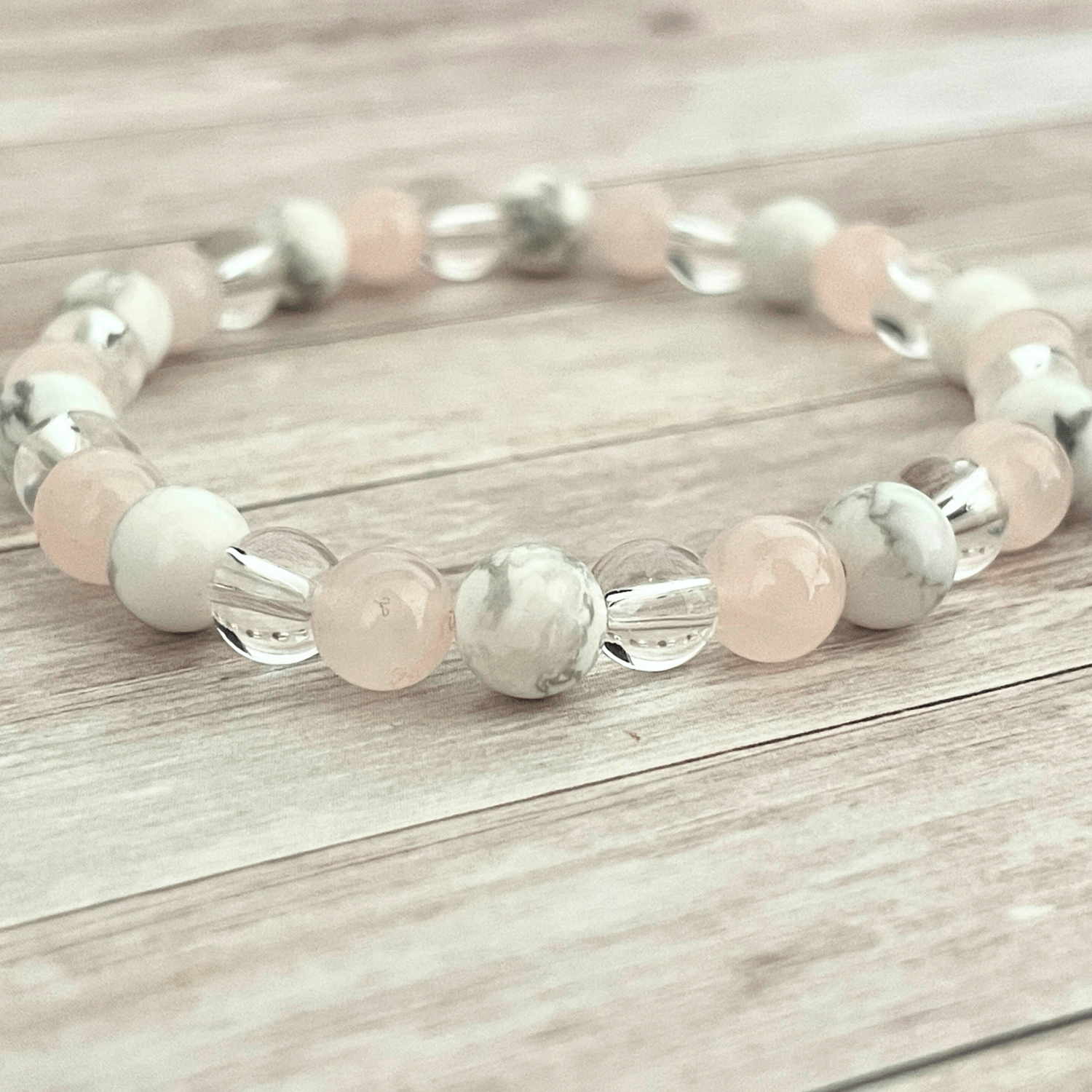 Gros plan sur les perles de quartz rose, howlite et cristal de roche du bracelet