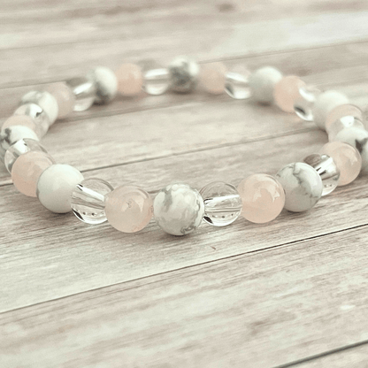 Gros plan sur les perles de quartz rose, howlite et cristal de roche du bracelet