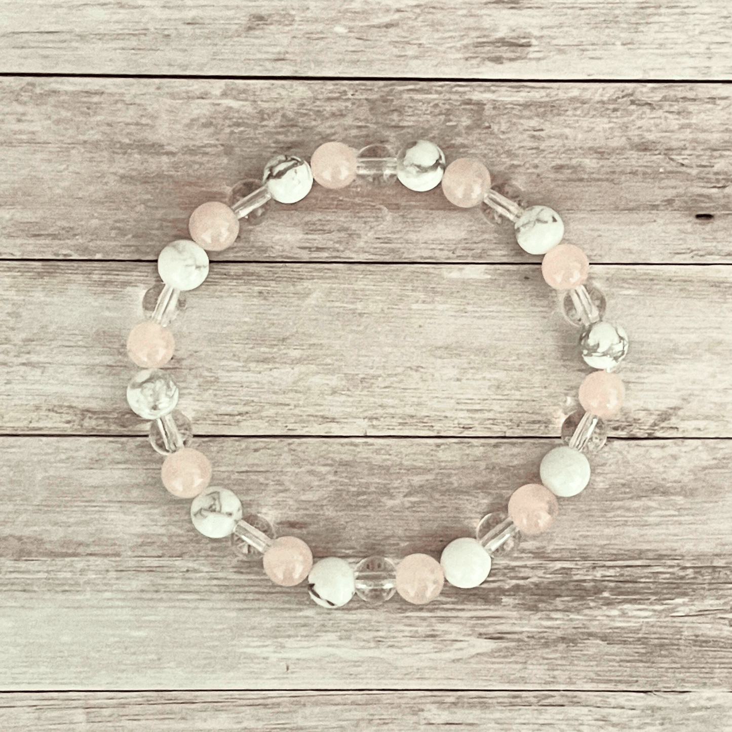 Vue de dessus du bracelet quartz rose, howlite et cristal de roche, perles alignées sur un fil élastique
