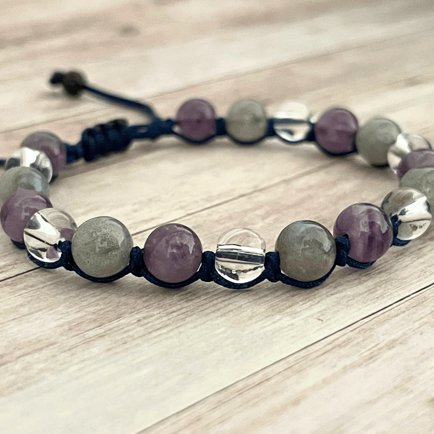 Gros plan sur les perles de labradorite, améthyste et cristal de roche du bracelet