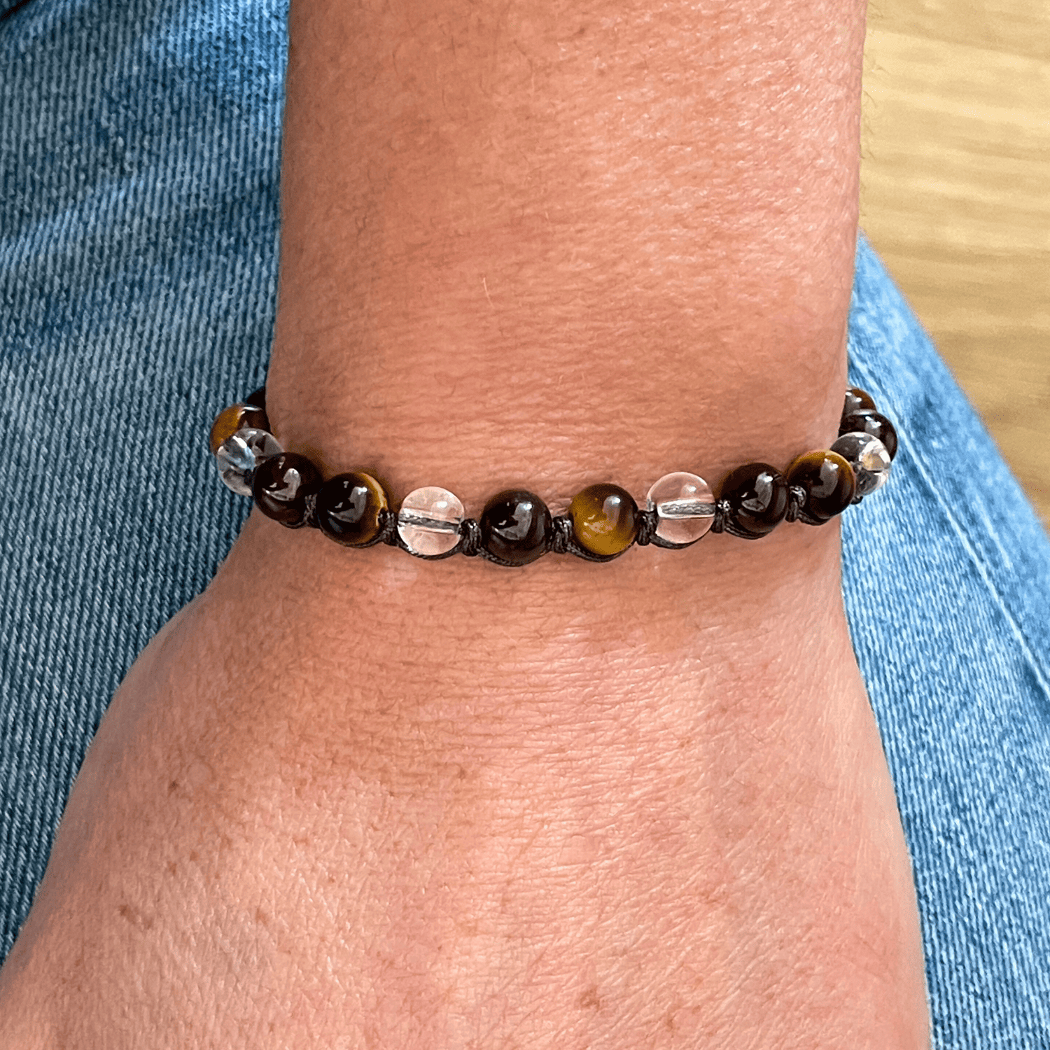 Bracelet grenat, oeil de tigre et cristal de roche porté au poignet, bijou en pierres naturelles