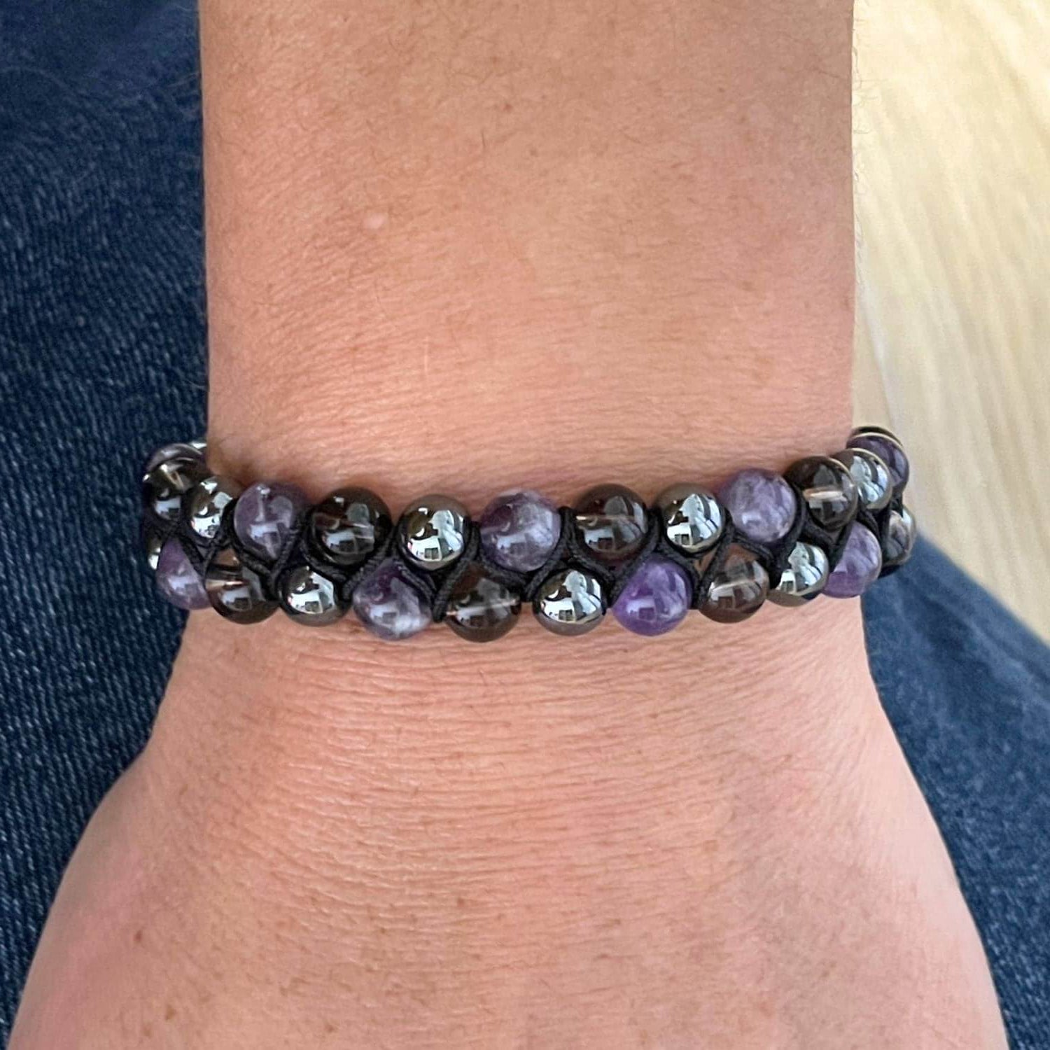 Bracelet Améthyste Hématite Quartz Fumé porté au poignet, bijou en pierres naturelles pour accompagner la transition et l'ancrage