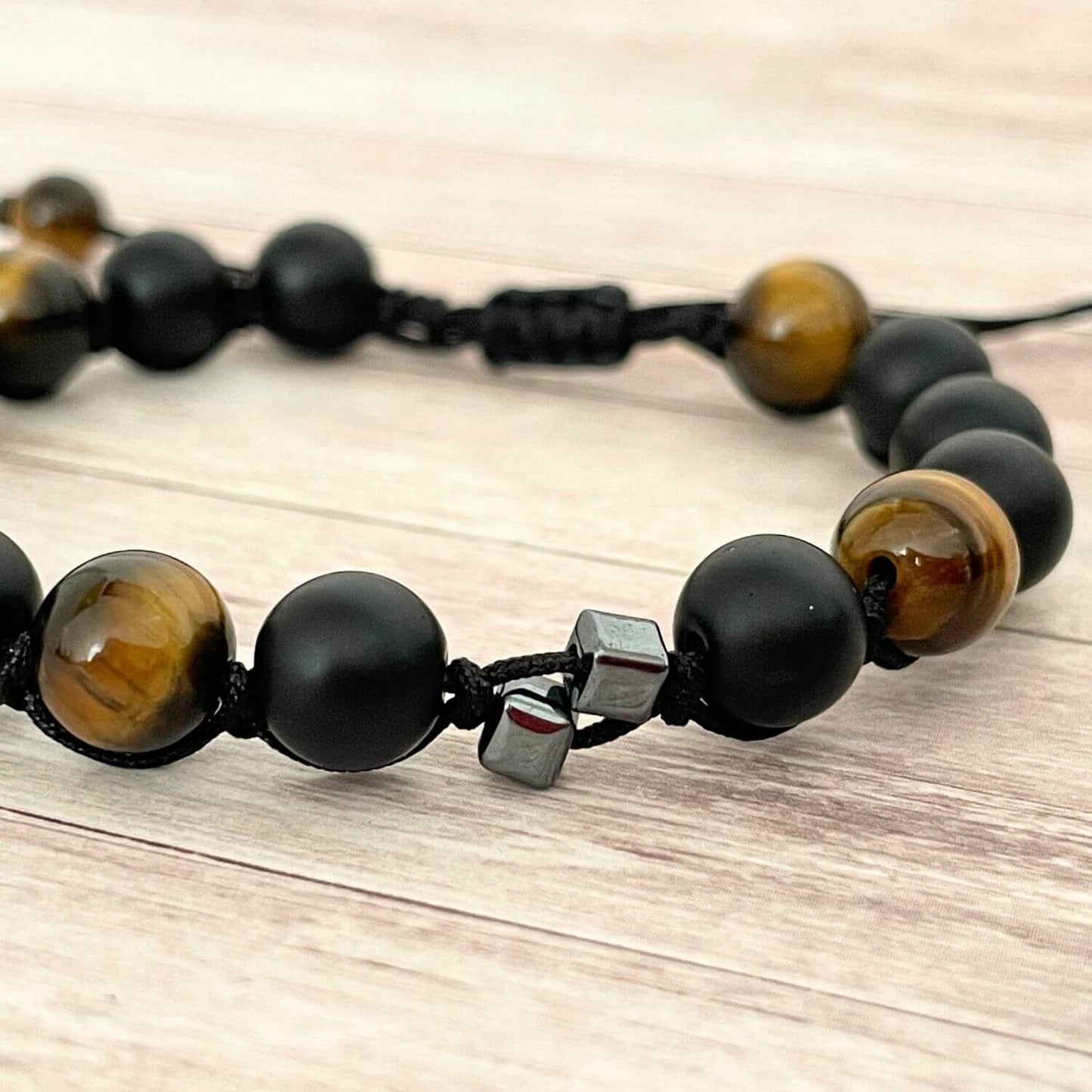 Détail des perles 8 mm Onyx et Œil de Tigre sur bracelet cordon ajustable