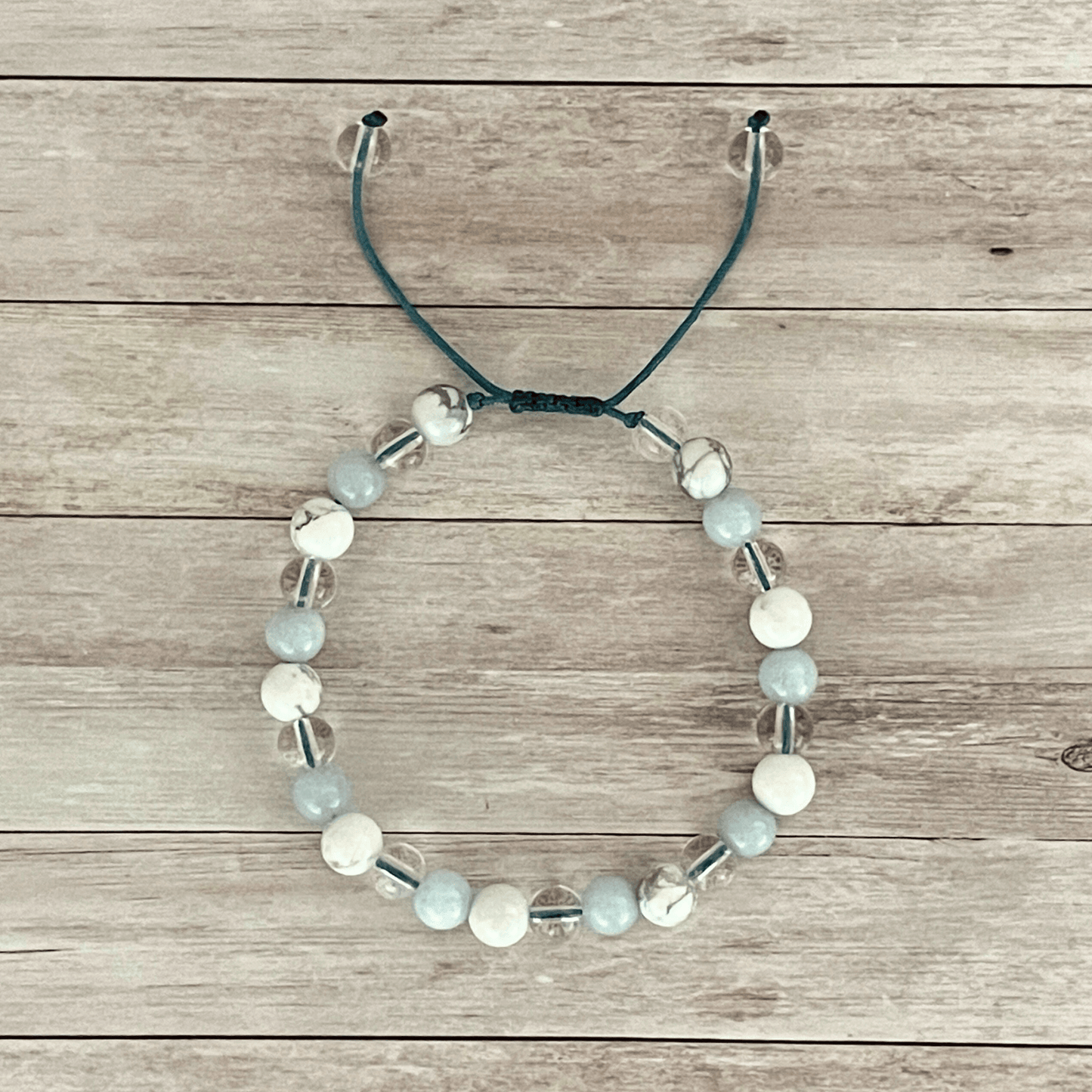 Vue de dessus du bracelet aigue marine, howlite et cristal de roche, perles alignées sur cordon