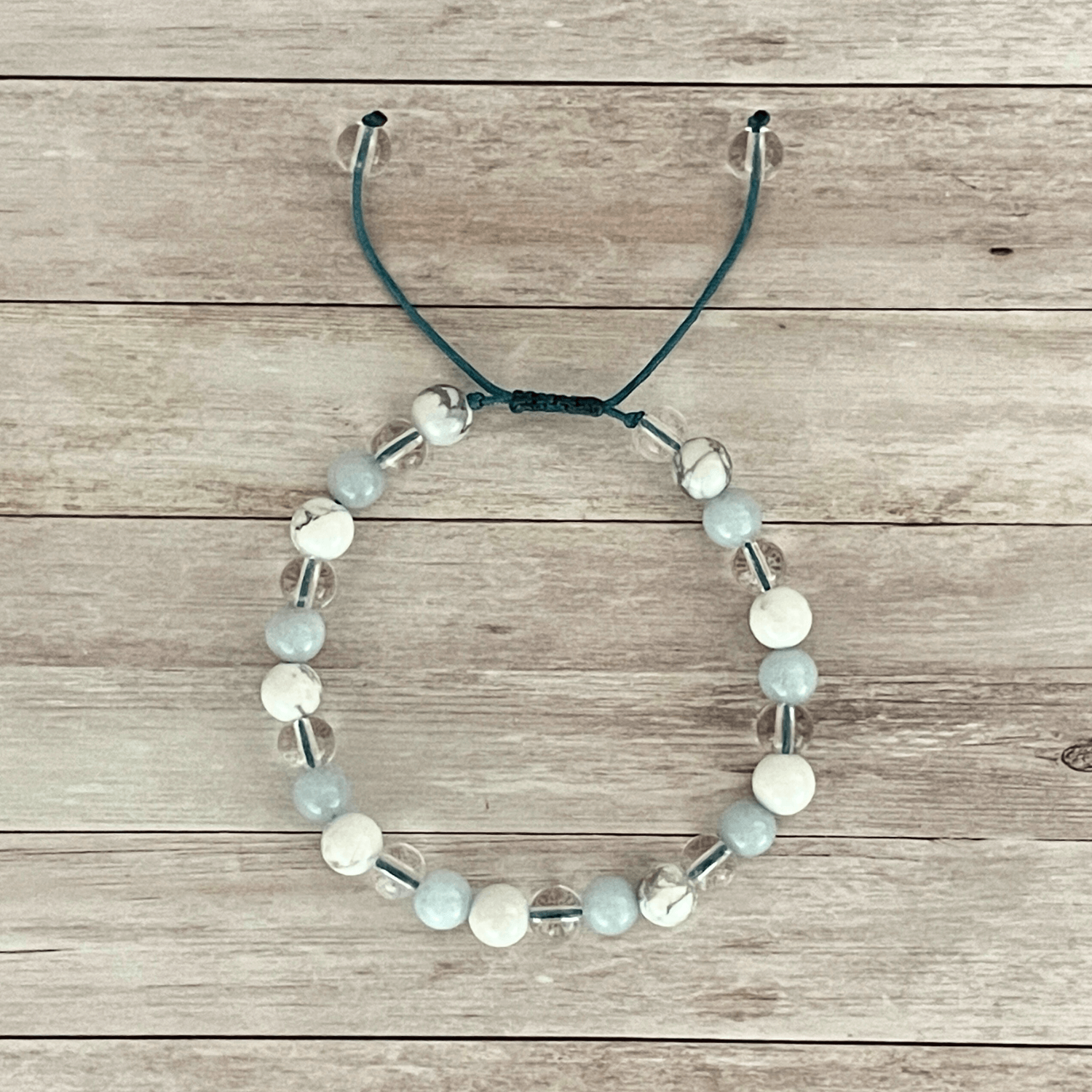 Vue de dessus du bracelet aigue marine, howlite et cristal de roche, perles alignées sur cordon