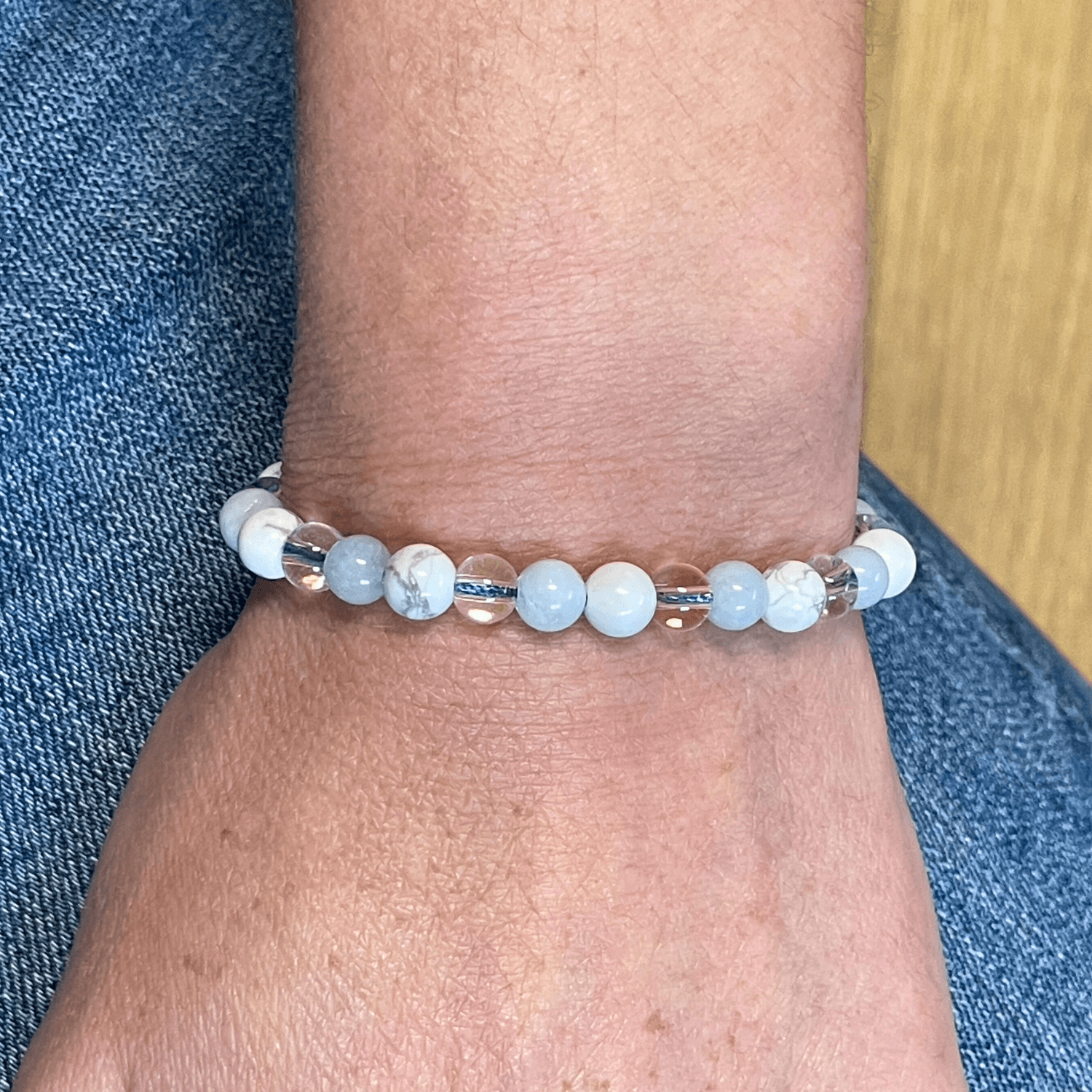 Bracelet aigue marine, howlite et cristal de roche porté au poignet, bijou en pierres naturelles