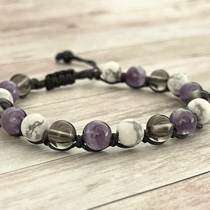 Gros plan sur les perles d’améthyste violette, howlite blanche et quartz fumé du bracelet